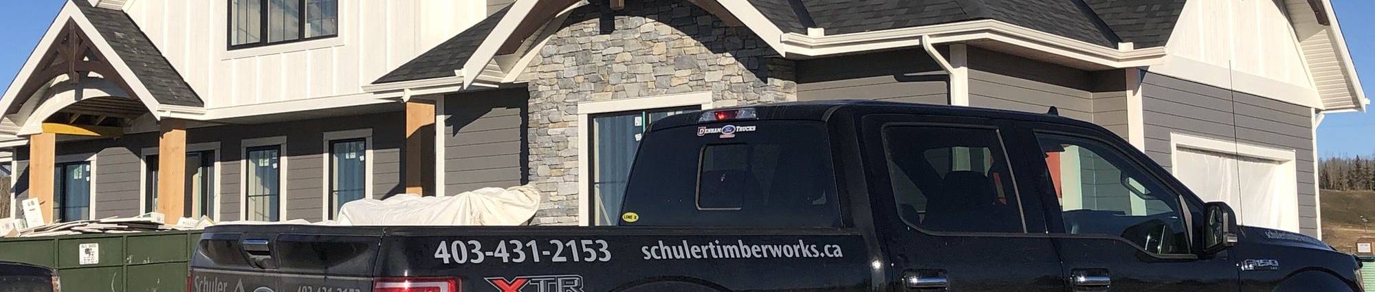 Large timber frame home and Schuler TImberworks truck